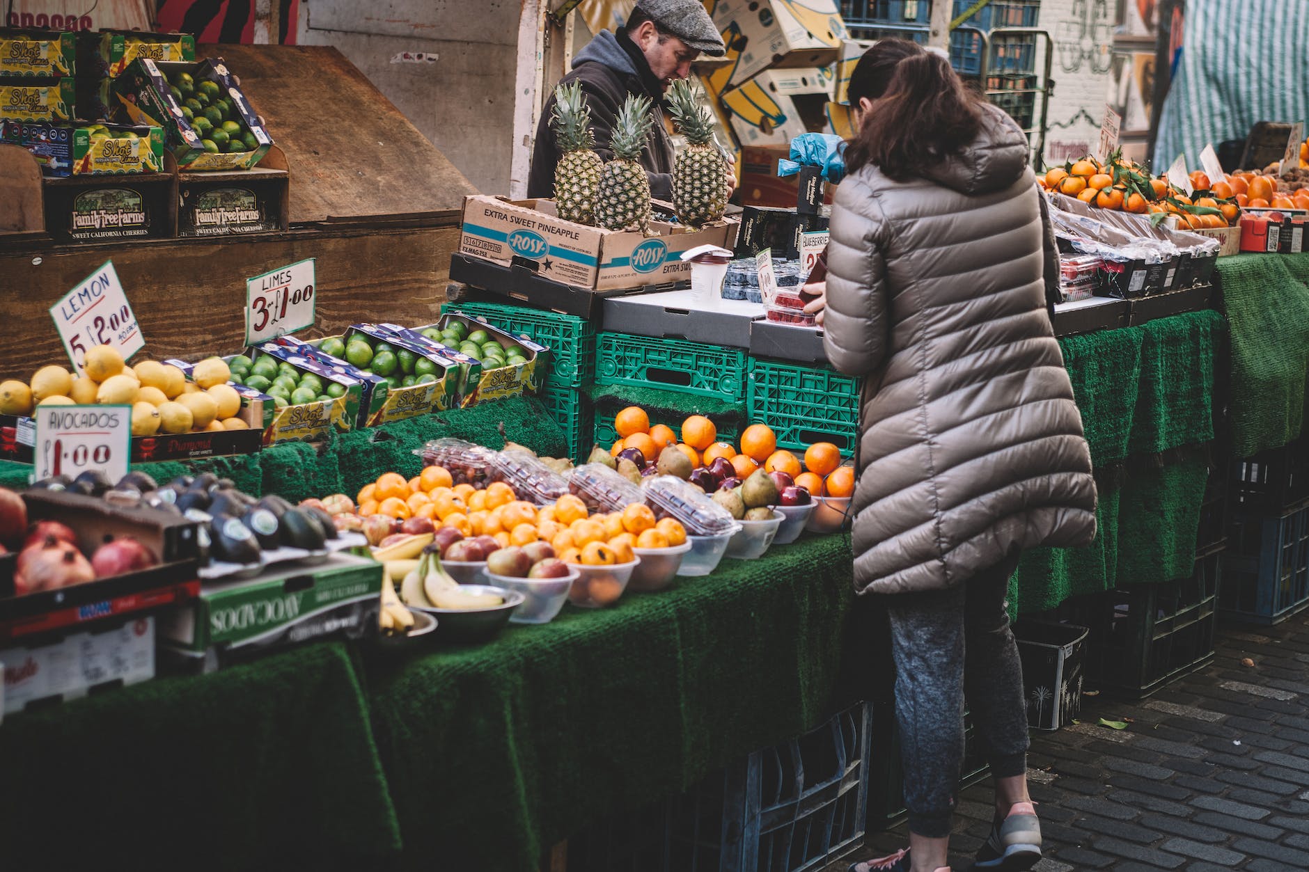 woman standing in front of assorted fruits displayed