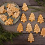 brown christmas tree shaped gingerbread cookies on wood background