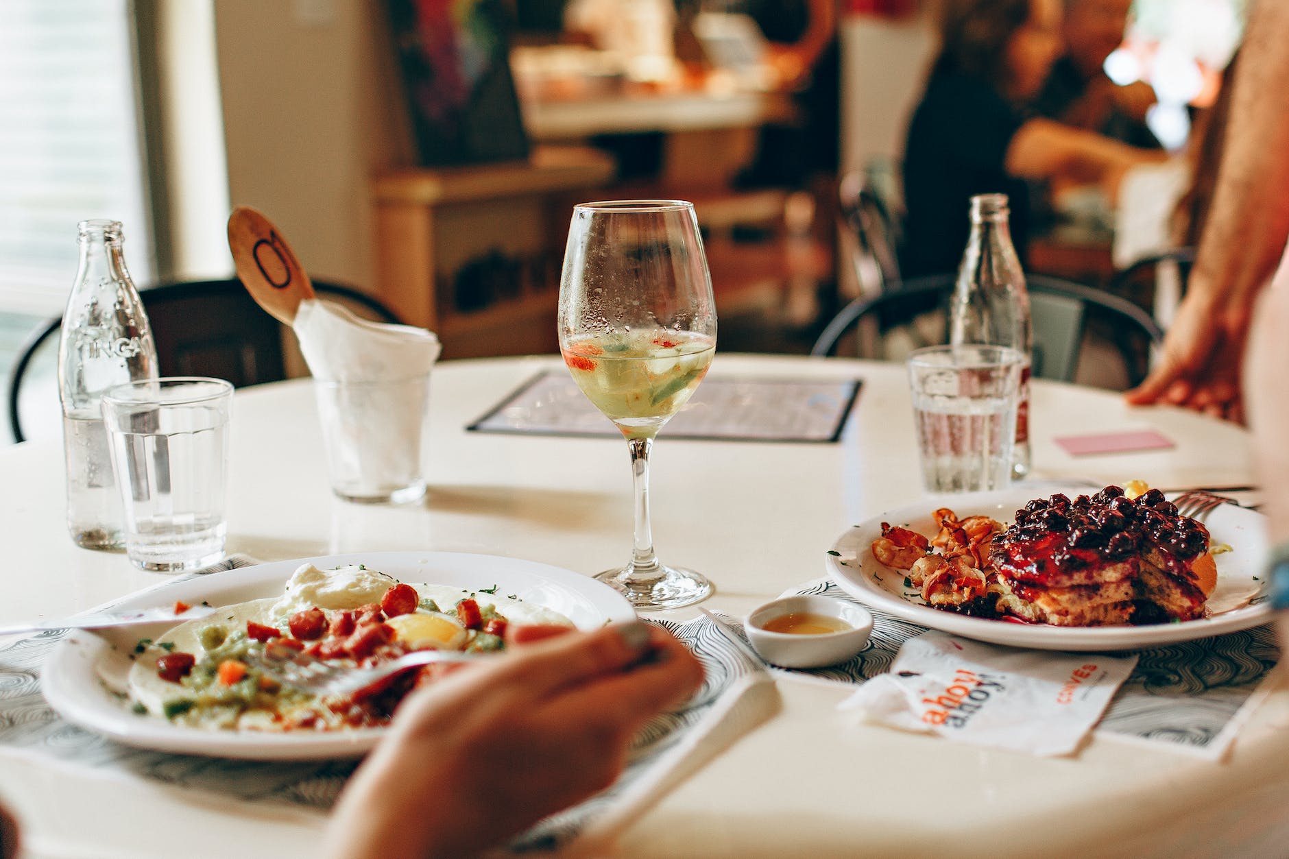 wine in clear glass near food on plate on table