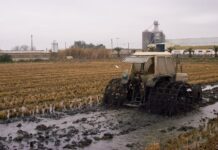 man in a tractor ploughing a flooded field